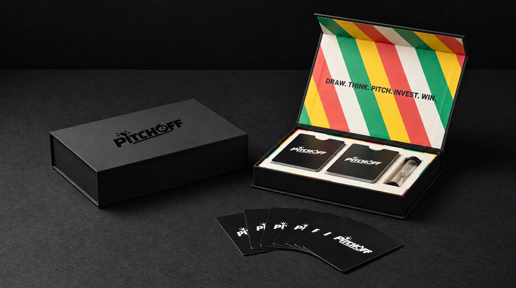 PITCH OFF matte black game box with embossed logo beside the open box, with green, yellow and coral striped lid, two decks of black PITCH OFF cards and a sand hourglass, and a fan of cards in front